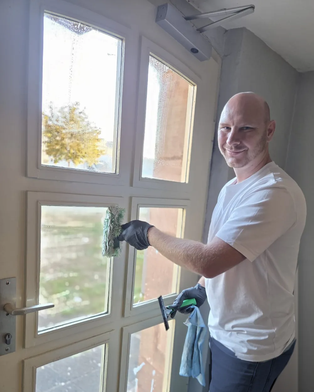 Hans-Georg Klein von Kleansmann Gebäudereinigung bei der Glasreinigung einer Haustür